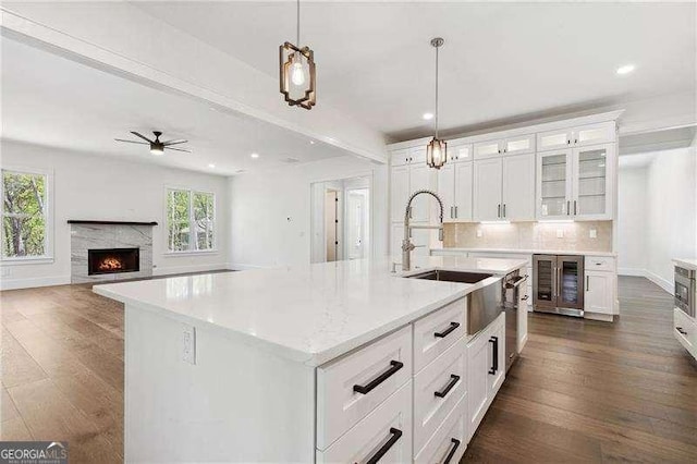 kitchen with a fireplace, dark wood-style flooring, a sink, and wine cooler