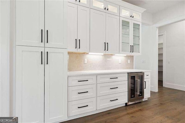 bar featuring tasteful backsplash, a dry bar, baseboards, dark wood-style flooring, and wine cooler
