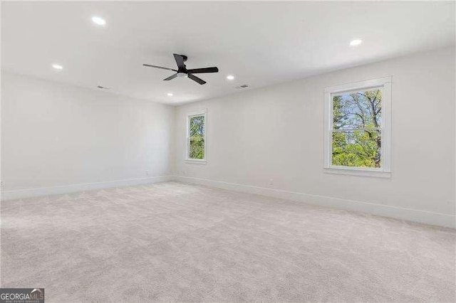 carpeted spare room featuring recessed lighting, a ceiling fan, and baseboards