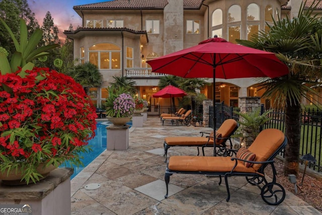 720 Heards Ferry Rd, Atlanta, GA 30328 - patio terrace at dusk featuring a fenced in pool, a balcony, and fence