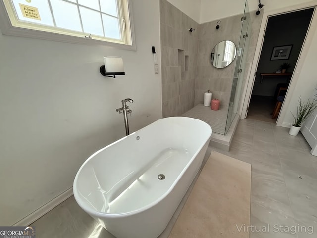 full bathroom with baseboards, a soaking tub, and a stall shower
