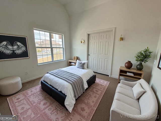 carpeted bedroom with high vaulted ceiling, a closet, and baseboards
