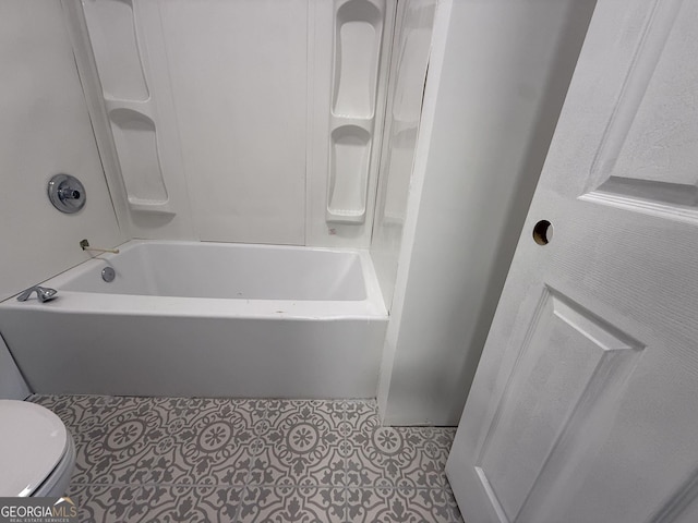 bathroom featuring bathtub / shower combination and toilet