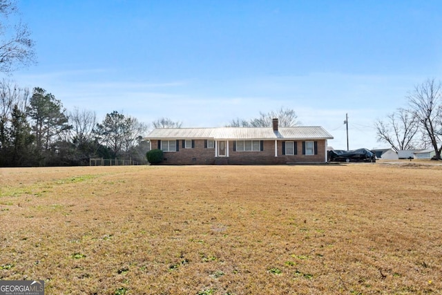 ranch-style house featuring brick siding, a front yard, and a chimney