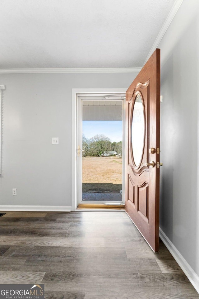 foyer entrance featuring crown molding, baseboards, and wood finished floors