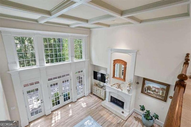living room with a high end fireplace, coffered ceiling, and beam ceiling