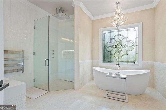 full bath with tile walls, an inviting chandelier, a stall shower, ornamental molding, and a soaking tub