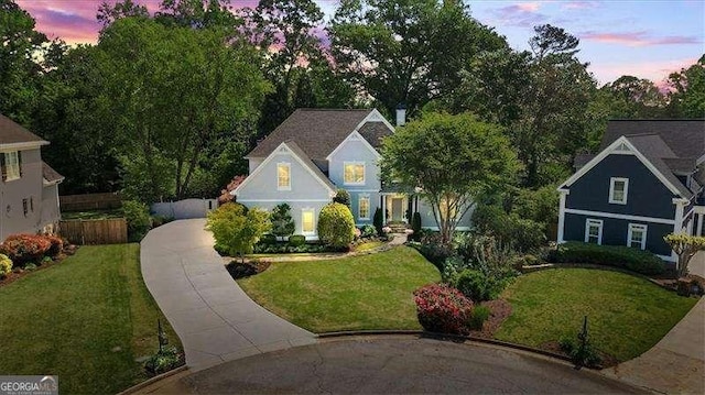 view of front of house with concrete driveway and a yard