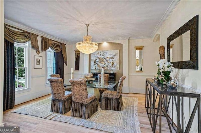 dining room featuring ornamental molding, a chandelier, light wood-style flooring, and baseboards