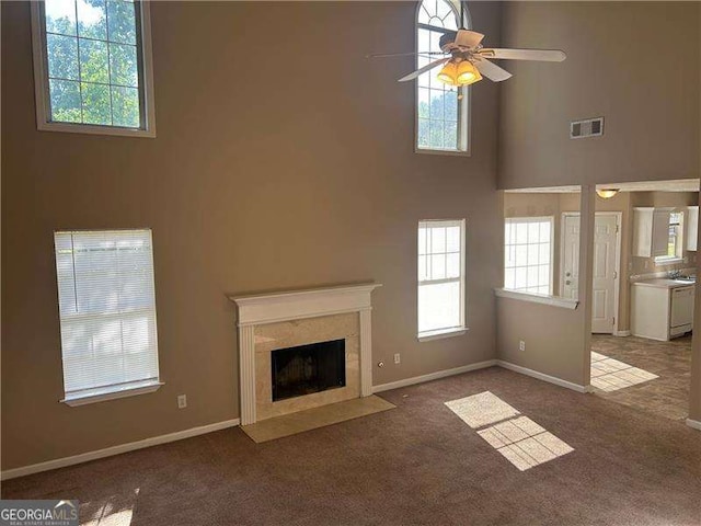 3334 Rockmill Dr, Ellenwood, GA 30294 - unfurnished living room with visible vents, carpet, a high ceiling, ceiling fan, and a high end fireplace