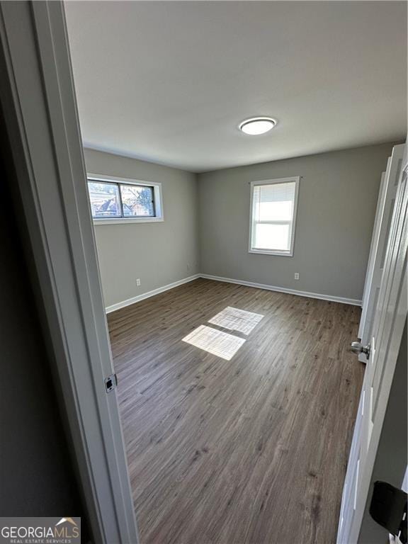 1401 Vesta Ave, East Point, GA 30344 - unfurnished bedroom featuring dark wood-type flooring, baseboards, and multiple windows