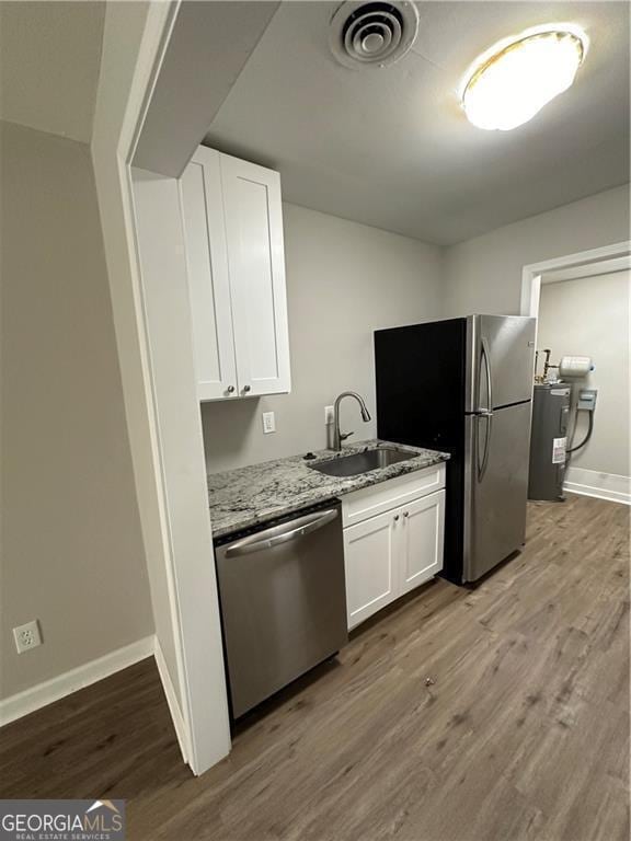 1401 Vesta Ave, East Point, GA 30344 - kitchen featuring light stone counters, stainless steel appliances, wood finished floors, visible vents, and a sink