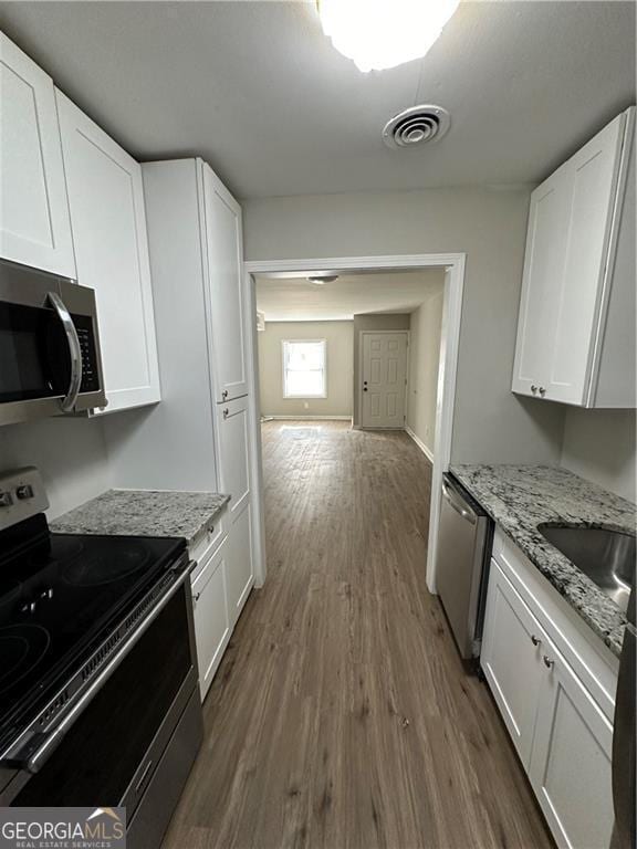 1401 Vesta Ave, East Point, GA 30344 - kitchen featuring a sink, white cabinetry, dark wood finished floors, appliances with stainless steel finishes, and visible vents