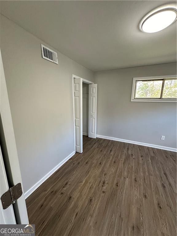 1401 Vesta Ave, East Point, GA 30344 - unfurnished bedroom featuring baseboards, visible vents, and dark wood-style floors