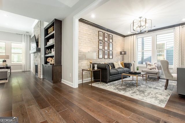living room with a healthy amount of sunlight, crown molding, and a notable chandelier