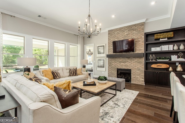 living room featuring dark wood finished floors, visible vents, a notable chandelier, a fireplace, and ornamental molding