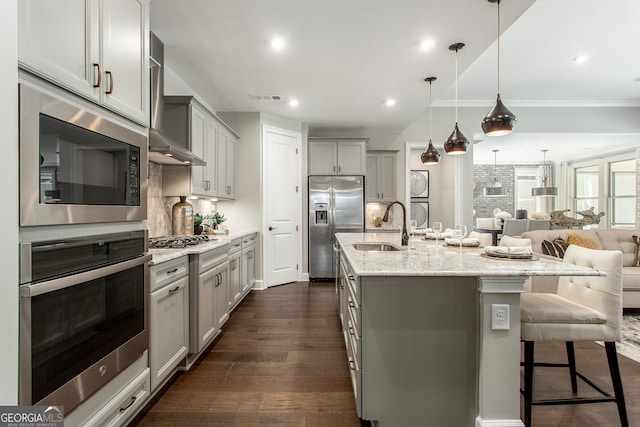 kitchen with wall chimney exhaust hood, stainless steel appliances, gray cabinetry, and a sink