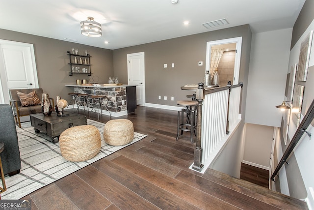 living room featuring recessed lighting, wood finished floors, visible vents, and baseboards