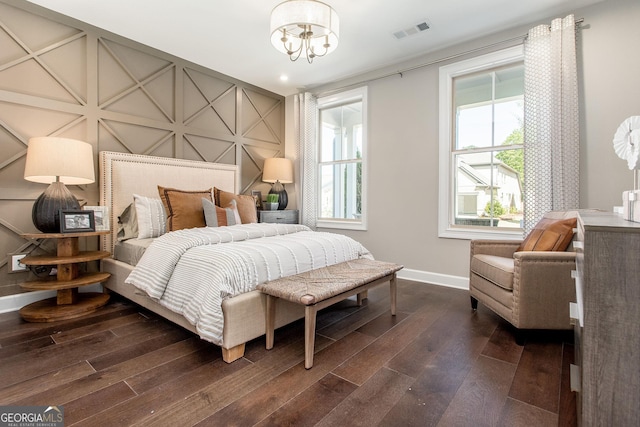 bedroom with baseboards, visible vents, a chandelier, and dark wood finished floors