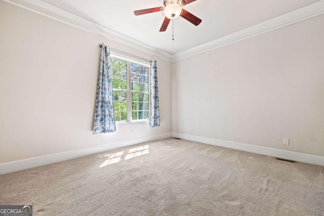 carpeted empty room with visible vents, ceiling fan, baseboards, and ornamental molding