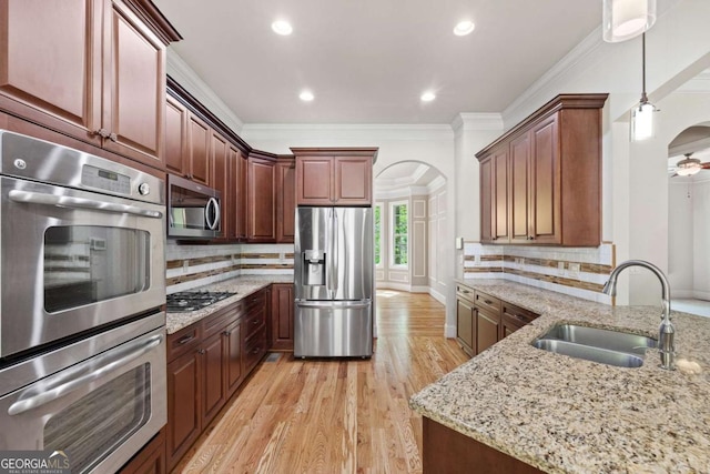 930 Riverside Rd, Roswell, GA 30075 - kitchen featuring appliances with stainless steel finishes, arched walkways, crown molding, light wood finished floors, and light stone countertops