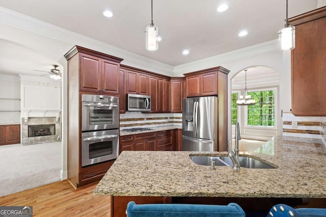 930 Riverside Rd, Roswell, GA 30075 - kitchen with stainless steel appliances, a peninsula, light stone counters, a breakfast bar area, and arched walkways