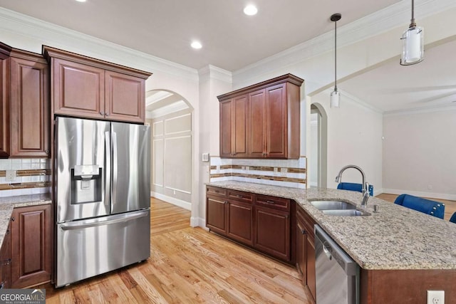 930 Riverside Rd, Roswell, GA 30075 - kitchen with appliances with stainless steel finishes, arched walkways, light wood finished floors, pendant lighting, and crown molding