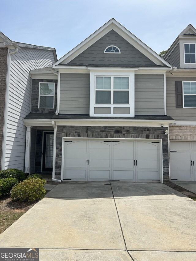 3908 Augustine Pl, Rex, GA 30273 - townhome / multi-family property featuring stone siding, an attached garage, and concrete driveway