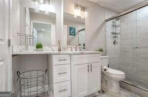 300 Peachtree St NE Unit 5A, Atlanta, GA 30308 - bathroom featuring a baseboard heating unit, vanity, a tile shower, and toilet