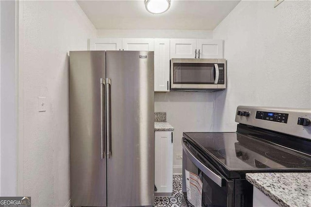 300 Peachtree St NE Unit 5A, Atlanta, GA 30308 - kitchen featuring white cabinets, light stone countertops, and appliances with stainless steel finishes