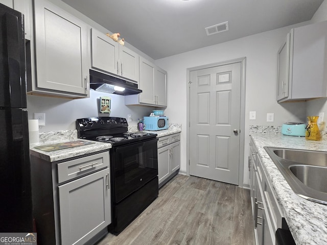 3202 Fairington Village Dr, Lithonia, GA 30038 - kitchen featuring a sink, black appliances, light wood finished floors, under cabinet range hood, and visible vents