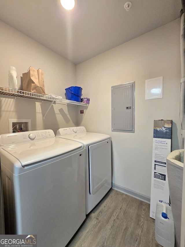 3202 Fairington Village Dr, Lithonia, GA 30038 - clothes washing area with wood finished floors, electric panel, washer and dryer, and laundry area