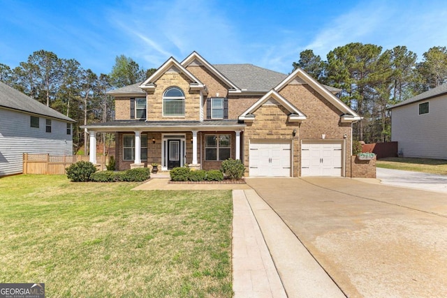 craftsman-style house featuring fence, driveway, covered porch, brick siding, and a front yard