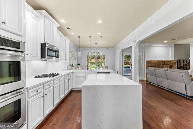 kitchen with a peninsula, dark wood-style floors, open floor plan, visible vents, and appliances with stainless steel finishes