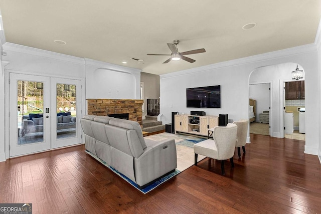 living room with arched walkways, visible vents, ceiling fan, ornamental molding, and wood-type flooring