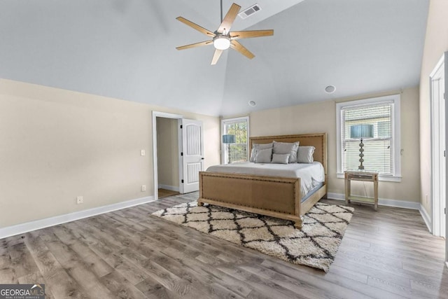 bedroom with wood finished floors, visible vents, baseboards, high vaulted ceiling, and ceiling fan