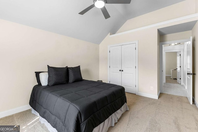 bedroom featuring light colored carpet, baseboards, vaulted ceiling, and a closet