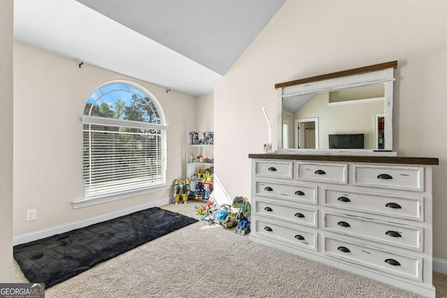 recreation room with vaulted ceiling, carpet floors, and baseboards