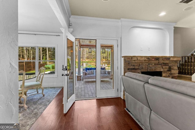 doorway to outside with a healthy amount of sunlight, crown molding, and dark wood-style floors