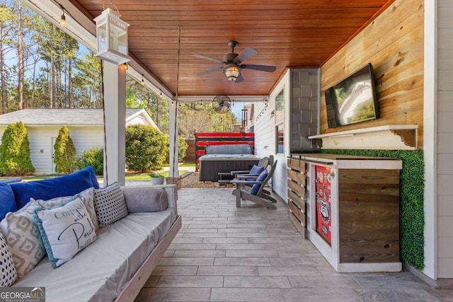 view of patio featuring an outdoor living space, a hot tub, and a ceiling fan