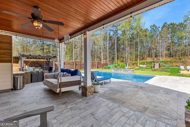 view of patio / terrace featuring a pergola, a playground, outdoor lounge area, a ceiling fan, and an outdoor pool