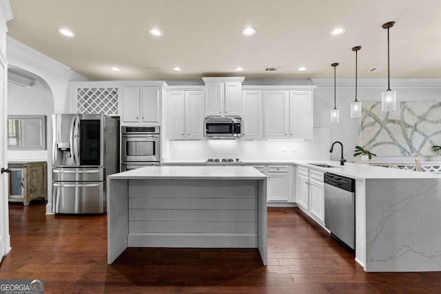 kitchen with a peninsula, a sink, recessed lighting, and appliances with stainless steel finishes