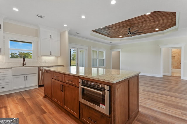88 Northshore Ave, Jesup, GA 31545 - kitchen with light wood finished floors, stainless steel appliances, a center island, plenty of natural light, and crown molding