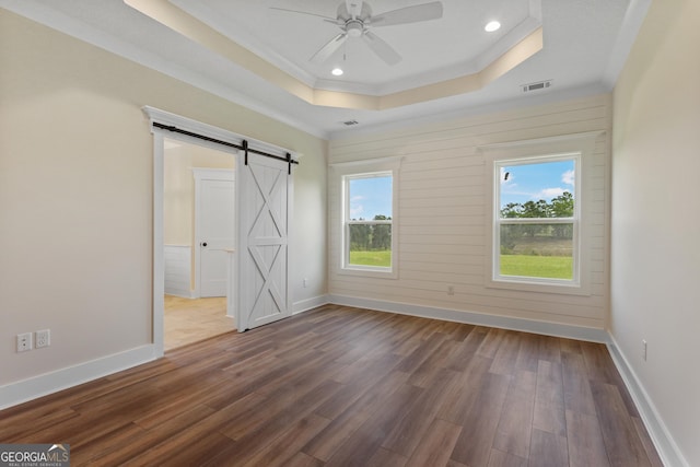 88 Northshore Ave, Jesup, GA 31545 - unfurnished bedroom featuring a tray ceiling, dark wood-style flooring, a barn door, baseboards, and ornamental molding