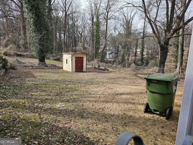 view of yard with a shed, an outbuilding, and fence