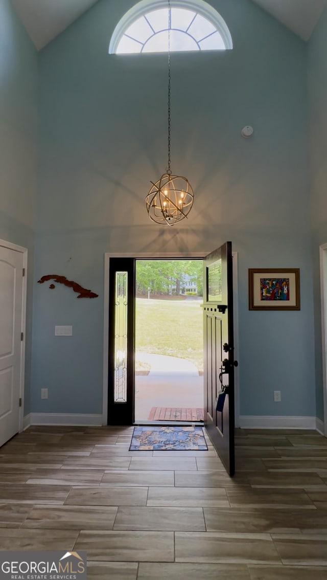 3440 Camelot Way, Loganville, GA 30052 - foyer entrance with wood tiled floor, a chandelier, a wealth of natural light, and high vaulted ceiling