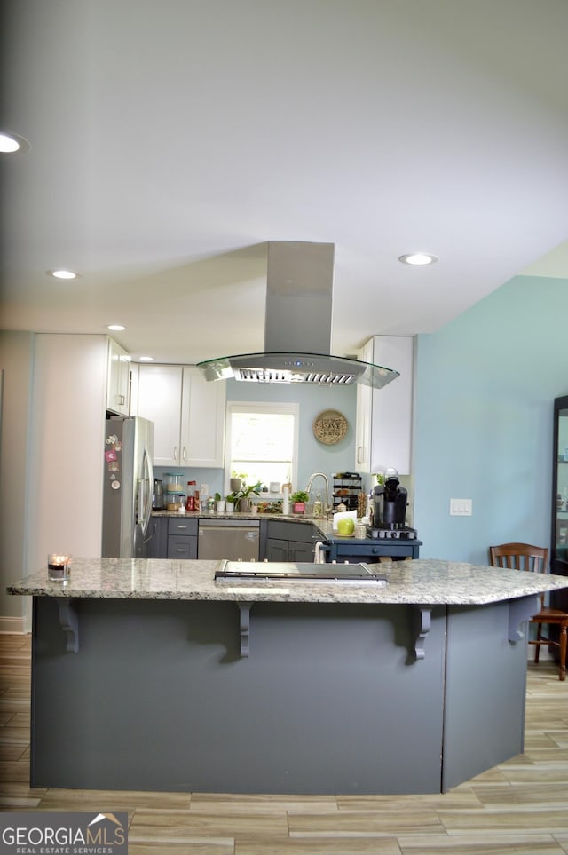 3440 Camelot Way, Loganville, GA 30052 - kitchen with a breakfast bar, stainless steel appliances, island exhaust hood, and light stone countertops