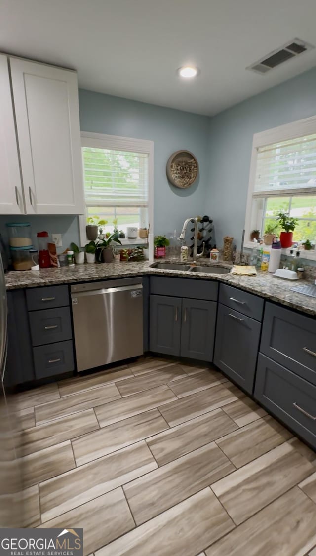 3440 Camelot Way, Loganville, GA 30052 - kitchen with visible vents, wood tiled floor, a sink, and dishwasher
