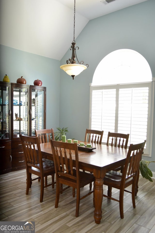3440 Camelot Way, Loganville, GA 30052 - dining room with visible vents, lofted ceiling, and light wood-type flooring