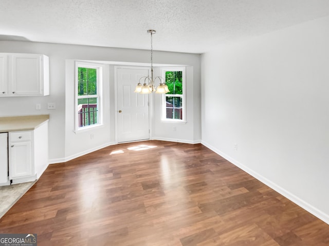45 Carroll St, Temple, GA 30179 - unfurnished dining area with baseboards, an inviting chandelier, wood finished floors, and plenty of natural light